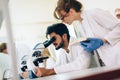 Young scientist looking through microscope in laboratory Royalty Free Stock Photo