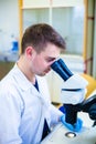 Young male scientist with a microscope checking his sample