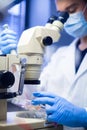 Young male scientist with a microscope working with sample