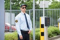 Security Guard Standing Beside Car Parking Machine Royalty Free Stock Photo