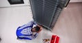 Young Male Serviceman Working On Fridge With Screwdriver Royalty Free Stock Photo