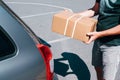 Young male shopper stacks cardboard boxes in the trunk of a car in a supermarket parking lot. Close-up view Royalty Free Stock Photo