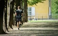 Young male in shorts and a t-shirt running on a tree-lined park Royalty Free Stock Photo