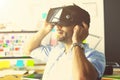 Young male software programmer testing a new app with 3d virtual reality glasses in office.