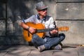 Young male street musician playing guitar on a city sidewalk. Freedom, music and art concept. Horizontal image Royalty Free Stock Photo