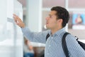 young male student checking notice board Royalty Free Stock Photo