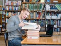 Young male student reading book in library Royalty Free Stock Photo