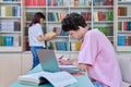 Young male student sitting with laptop with books in college library Royalty Free Stock Photo