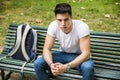 Young Male Student Sitting on Park Bench Seriously Royalty Free Stock Photo