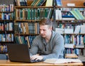 Young male student using laptop in the university library Royalty Free Stock Photo
