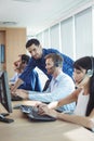 Young male supervisor assisting telemarketer at call center Royalty Free Stock Photo