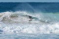 Young male surfer locked in the tube of wave