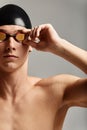 Young male swimmer preparing for the start, close-up portrait of a swimmer in a mask and a hat, gray background, copy Royalty Free Stock Photo