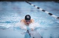 Young male swimmer swims the breaststroke in a competition