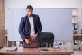 Young male teacher physicist in the classroom