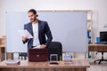 Young male teacher physicist in the classroom