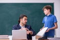 Young male teacher and schoolboy in the classroom