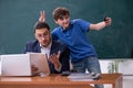 Young male teacher and schoolboy in the classroom