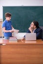 Young male teacher and schoolboy in the classroom