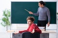 Young male teacher and schoolboy in the classroom