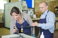 Young male technician in blue overall in metalworks workshop