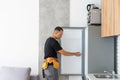 Young Male Technician Checking Fridge With Digital Multimeter Royalty Free Stock Photo