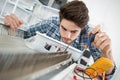 Young male technician checking radiator with screwdriver