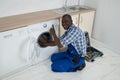 Young Male Technician Fixing Washing Machine Royalty Free Stock Photo