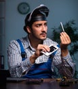Young male technician repairing computer in workshop at night Royalty Free Stock Photo