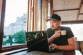 A young male tourist blogger freelancer working on a laptop in a cafe in Istanbul. A view from the window to the world