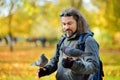 Young male tourist feeding pigeons in St James`s Park in London, United Kingdom, on beautiful sunny autumn day