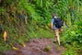 Young male tourist hiking on the famous Kalalau trail along Na Pali coast of the island of Kauai Royalty Free Stock Photo