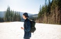 Young male tourist on a walk on the snowy slopes of the Carpathians with a backpack on his back and looks away Royalty Free Stock Photo