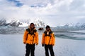 Young Male Tourist with yellow jacket in Antarctica smiling. Icebergs in background. Hiking with backpack in mountains Royalty Free Stock Photo