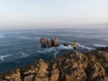 Tourist standing at Urro del Manzano rock formation natural arch bridge in Liencres Arnia Santander Cantabria Spain