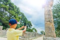 Young male traveler making photo. Famous Archaeological Site of Olympia. Peloponnese, Greece. Travel concept