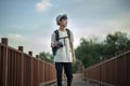 Young male traveler photographer walking on wooden bridge with backpack and holding a camera Royalty Free Stock Photo