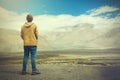 Young male traveler standing on the sand cliff, thinking about or looking forward to something in Leh, Ladakh,India Royalty Free Stock Photo