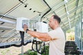 Young male turning on solar panel. Royalty Free Stock Photo