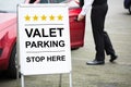 Young Male Valet Standing Near Valet Parking Sign