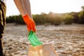 Young male volunteer picks up plastic garbage on the ocean coast. A man collects waste on the seaside to save ecology and protect Royalty Free Stock Photo