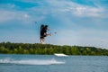 Male wakeboarder jumping over water with board holding rope Royalty Free Stock Photo