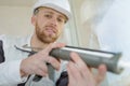 Young male worker applying glue with silicone gun Royalty Free Stock Photo