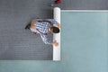 Young Male Worker In Overalls Rolling Carpet