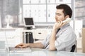 Young male working in office talking on phone