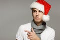 Young male in Xmas hat pointing to the side