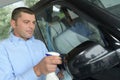 Young man accurately cleaning cars miror