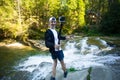 Young man with action camera walk near fast river