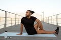 young man in activewear performing seated spinal twist asana outdoor Royalty Free Stock Photo