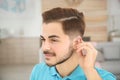Young man adjusting hearing aid Royalty Free Stock Photo